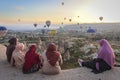 women in traditional dress watch the hot-air balloon show
