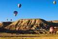 Hot air balloons festival in Cappadocia. Scenic view of landing balloons on the valley after morning flight