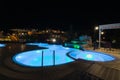 Picturesque night lights landscape of cave hotel in Goreme. Illuminated swimming-pool in the middle of terrasse.