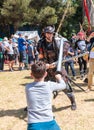 A knight festival participant dressed in a samurai costume fights with a small visitor on foam rubber swords in Goren park in Isra