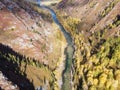 In the gorge below there is a mountain river, Evening light of the sun, autumn grasses