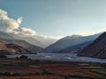 Gorge of the Kali Gandaki river with high cliffs and the valley with farm fields and sunset rays