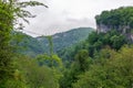 A gorge in the mountains with a suspension bridge over it. Skybridge suspension bridge over a precipice on a cloudy day. SkyPark,