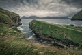 Gorge in the village of Gjogv on Eysturoy with green grass in front and Kalsoy in back, Faroe Islands