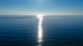 A gorgeous aerial shot of the vast blue ocean water at sunset with light reflecting off the water and clear blue sky Royalty Free Stock Photo