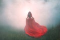 Gorgeous amazing wonderful scarlet red dress with a long flying waving train, a mysterious girl with red curly hair runs Royalty Free Stock Photo