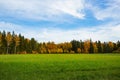 Gorgeous autumn colorful nature landscape view. Beautiful nature backgrounds. Green yellow trees and grass field on blue sky. Royalty Free Stock Photo