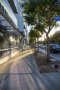 A gorgeous autumn landscape along smooth concrete sidewalk surrounded by lush green trees, autumn colored trees and cars