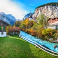 Gorgeous autumn landscape of alpine village Lauterbrunnen with famous church and Staubbach waterfall