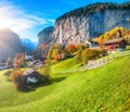 Gorgeous autumn landscape of  alpine village Lauterbrunnen with famous church and Staubbach waterfall Royalty Free Stock Photo