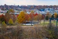 A gorgeous autumn landscape in the city with a circular park surrounded by autumn colored trees with tall light posts Royalty Free Stock Photo