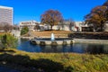 A gorgeous autumn landscape in the park with a still green lake and a water fountain in the center of the lake