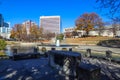 A gorgeous autumn landscape in the park with a still green lake and a water fountain in the center of the lake