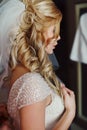 Gorgeous blonde bride posing in vintage white dress in hotel room closeup Royalty Free Stock Photo