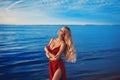 A gorgeous blonde girl in a sexy red dress with deep slits on the hips Royalty Free Stock Photo