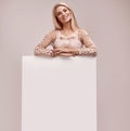 Gorgeous blonde woman holding a blank billboard Royalty Free Stock Photo