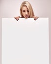 Gorgeous blonde woman holding a blank billboard Royalty Free Stock Photo