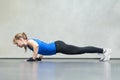 Gorgeous blonde woman warming up and doing some push ups a the gym, Sports concept healthy lifestyle and fitness. side view Royalty Free Stock Photo