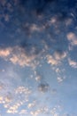 Pretty blue skies at sunrise, with cloud cover breaking up to let rays of sunlight and promise of a new day through Royalty Free Stock Photo