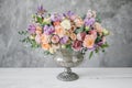 Gorgeous bouquet of different flowers. floral arrangement in vintage metal vase. table setting. lilac and peach color Royalty Free Stock Photo