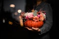 gorgeous bouquet of flowers in pumpkin on female hand. Decoration for thanksgiving day and halloween Royalty Free Stock Photo