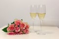 Two glasses of champagne and a bouquet made of beautiful light red / blush pink roses Royalty Free Stock Photo