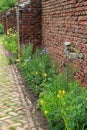 Gorgeous brick wall and walkway lined with flowers Royalty Free Stock Photo
