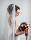 Gorgeous bride in classy dress poses with a red wedding bouquet of roses and peonies Royalty Free Stock Photo