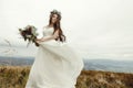 gorgeous bride dancing and having fun holding dress, boho wedding, luxury ceremony at mountains