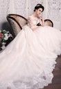 Gorgeous bride with dark hair in luxuious wedding dress