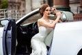 Gorgeous bride with fashion makeup and hairstyle near luxury wedding dress near white cabriolet car Royalty Free Stock Photo