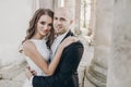 Gorgeous bride and groom embracing in evening sunlight near old castle in park. Romantic moment. Stylish wedding couple gently Royalty Free Stock Photo