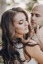 Gorgeous bride and groom embracing in evening sunlight near old castle in park. Romantic moment. Stylish wedding couple gently Royalty Free Stock Photo