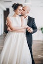 Gorgeous bride and groom gently hugging and dancing at wedding reception in restaurant. Beautiful stylish wedding couple Royalty Free Stock Photo