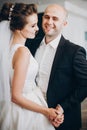 Gorgeous bride and groom gently hugging and dancing at wedding reception in restaurant. Happy  stylish wedding couple performing Royalty Free Stock Photo