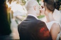 Gorgeous bride and groom gently kissing in sunset light. Portraits of beautiful tender wedding couple embracing in warm sunshine Royalty Free Stock Photo