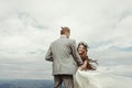 Gorgeous bride and groom holding hands and dancing at sky and cl Royalty Free Stock Photo