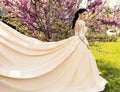 Gorgeous bride in luxurious wedding dress, posing in blossom garden Royalty Free Stock Photo