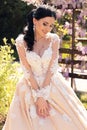 Gorgeous bride in luxurious wedding dress, posing in blossom garden Royalty Free Stock Photo