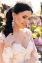 Gorgeous bride in luxurious wedding dress, posing in blossom garden Royalty Free Stock Photo