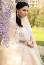 Gorgeous bride in luxurious wedding dress, posing in blossom garden Royalty Free Stock Photo