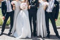 gorgeous bride with peony bouquet and stylish groom posing in sunny garden with bridesmaids and groomsmen on wedding day. luxury