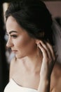 Gorgeous bride putting on luxury earrings. beautiful woman portrait of getting ready for wedding. sensual moment. sexy girl posing