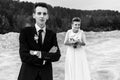 Gorgeous bride and stylish groom holding hands and looking at sandy beach lake, black and white photo, luxury wedding Royalty Free Stock Photo