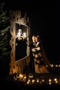 Gorgeous bride and stylish groom hugging at  romantic candle light arch under blanket at evening wedding ceremony, gentle moment Royalty Free Stock Photo