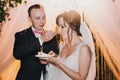 Gorgeous bride and stylish groom tasting delicious wedding cake with fresh strawberries at wedding reception in restaurant. Luxury Royalty Free Stock Photo