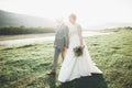 Gorgeous bride and stylish groom walking at sunny landscape, wedding couple, luxury ceremony mountains with amazing view Royalty Free Stock Photo