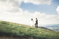 Gorgeous bride and stylish groom walking at sunny landscape, wedding couple, luxury ceremony mountains with amazing view Royalty Free Stock Photo