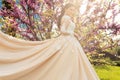 Gorgeous bride in wedding dress and crown posing in blossom summer garden Royalty Free Stock Photo