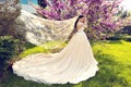 Gorgeous bride in wedding dress and crown posing in blossom summer garden Royalty Free Stock Photo